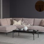 Photo d'ambiance d'un canapé 3 places avec une chaise longue XL. Tissu velours rose poudré. Pied en métal noir matte.